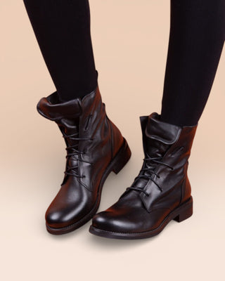 Front angled view of a model wearing Phantom black leather lace-up boots.