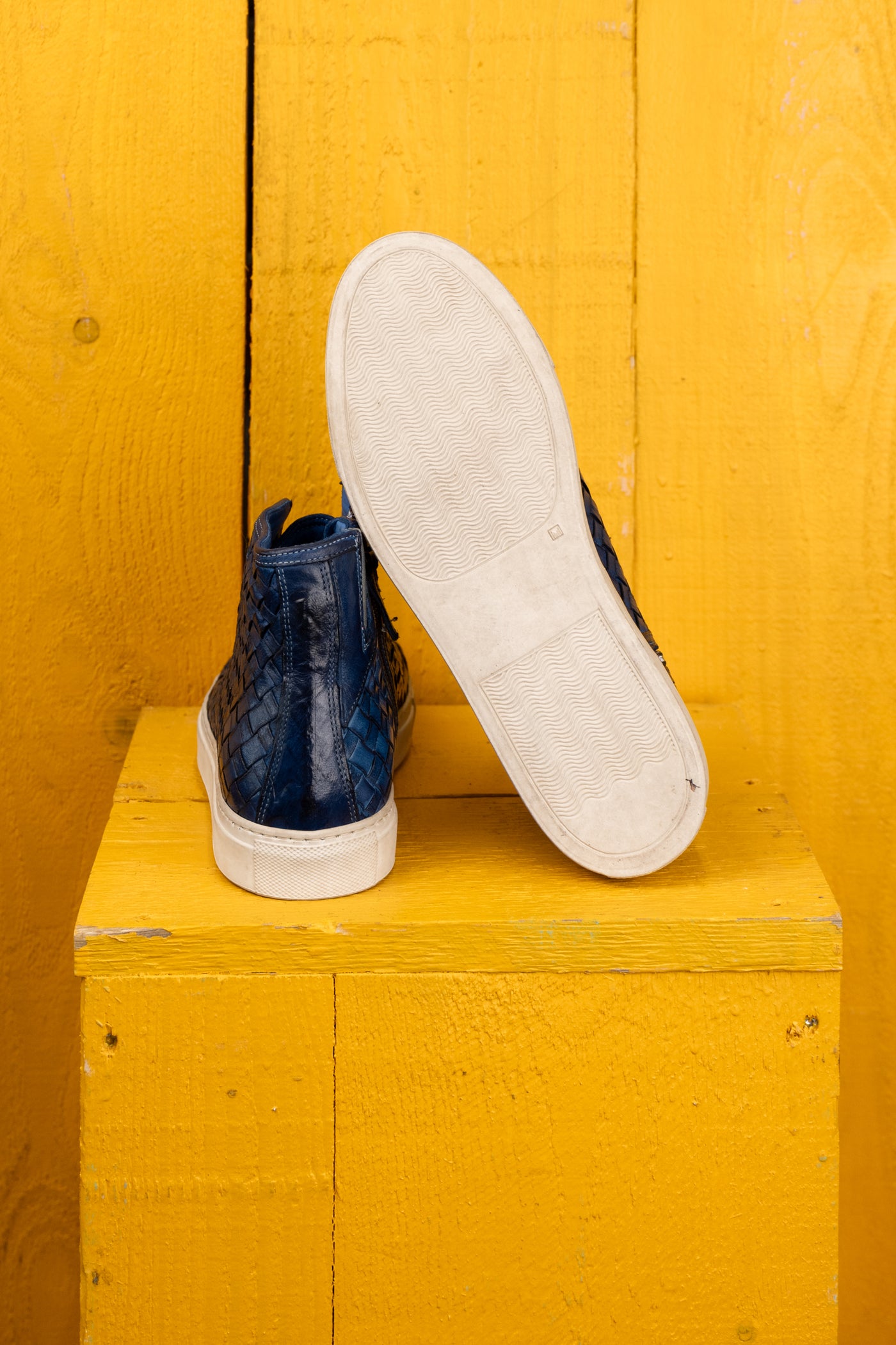 Rear view of Raimondo 8393 indigo woven leather high-top sneakers by Benheart, close-up of white rubber soles.