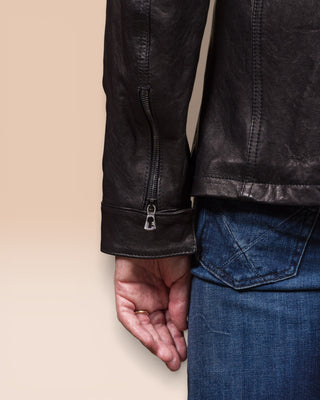 Close-up of the left cuff from the back, showing Benheart symbol-shaped zipper pull on the black Simone jacket.