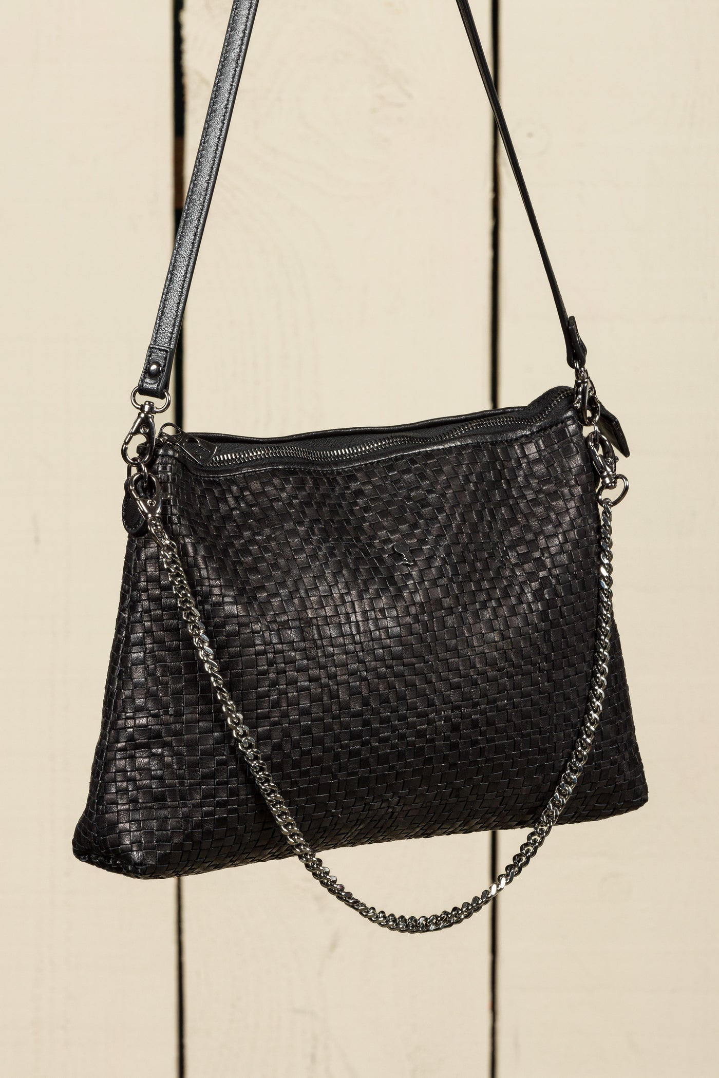 Benheart Violet Intrecciata black handwoven leather bag, three-quarter rear view, woven leather pattern, chain and leather shoulder strap, zipper closure, luxury designer handbag for women.