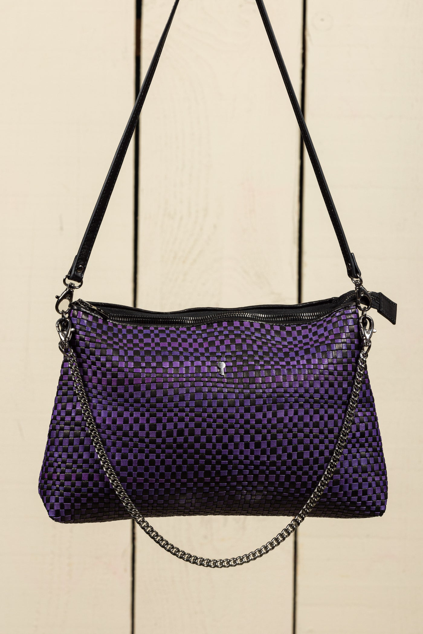 Front view of the Benheart Violet Intrecciata handwoven leather bag in black and violet, featuring a woven pattern, chain and leather shoulder strap, zipper closure.