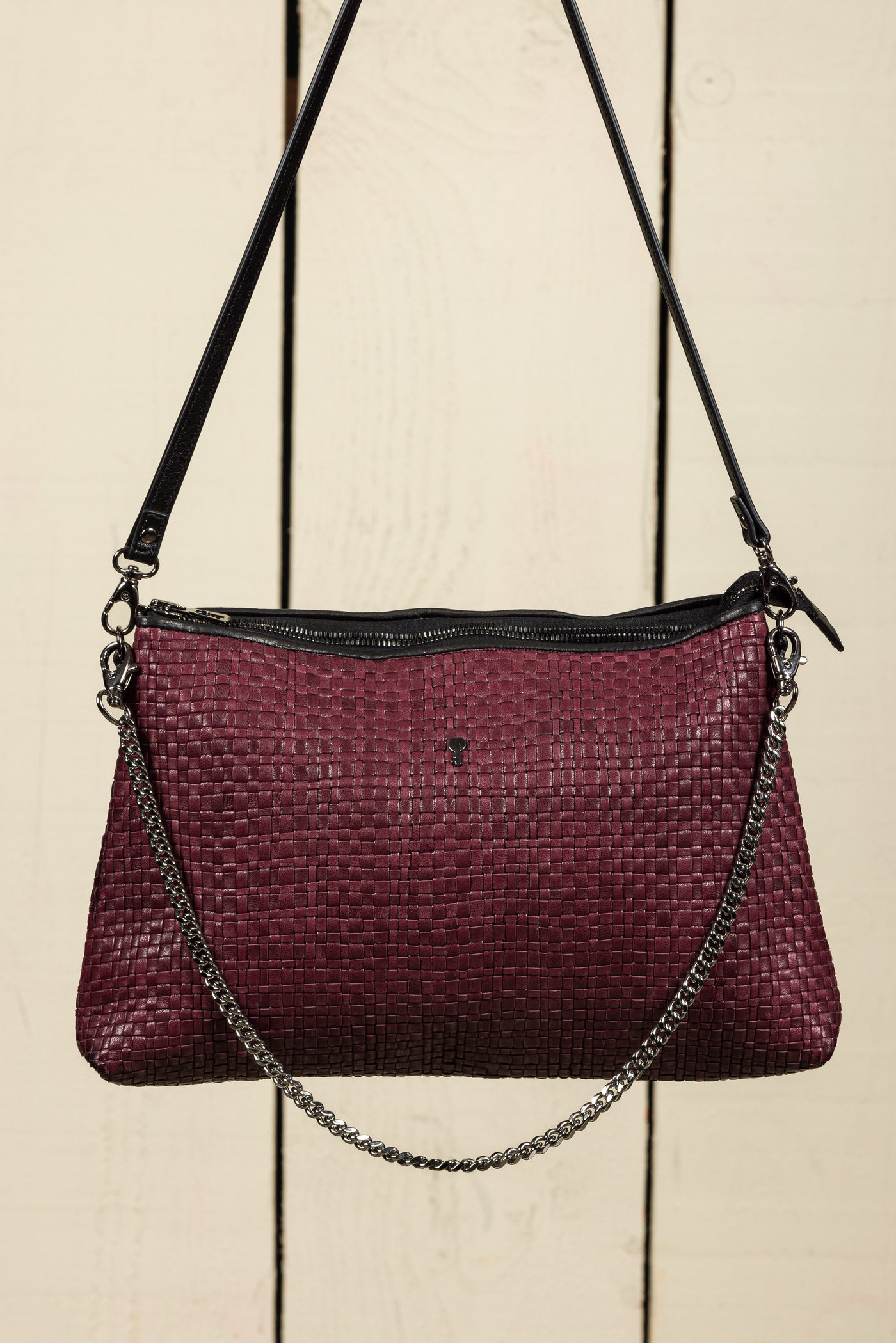 Front view of the Benheart Violet Intrecciata handwoven leather bag in plum, featuring a woven pattern, chain and leather shoulder strap, zipper closure.