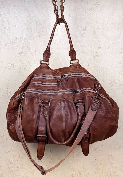 Angled front and top view of the Benheart Viaggio unisex cuoio leather travel bag, showing multiple zippers, handles