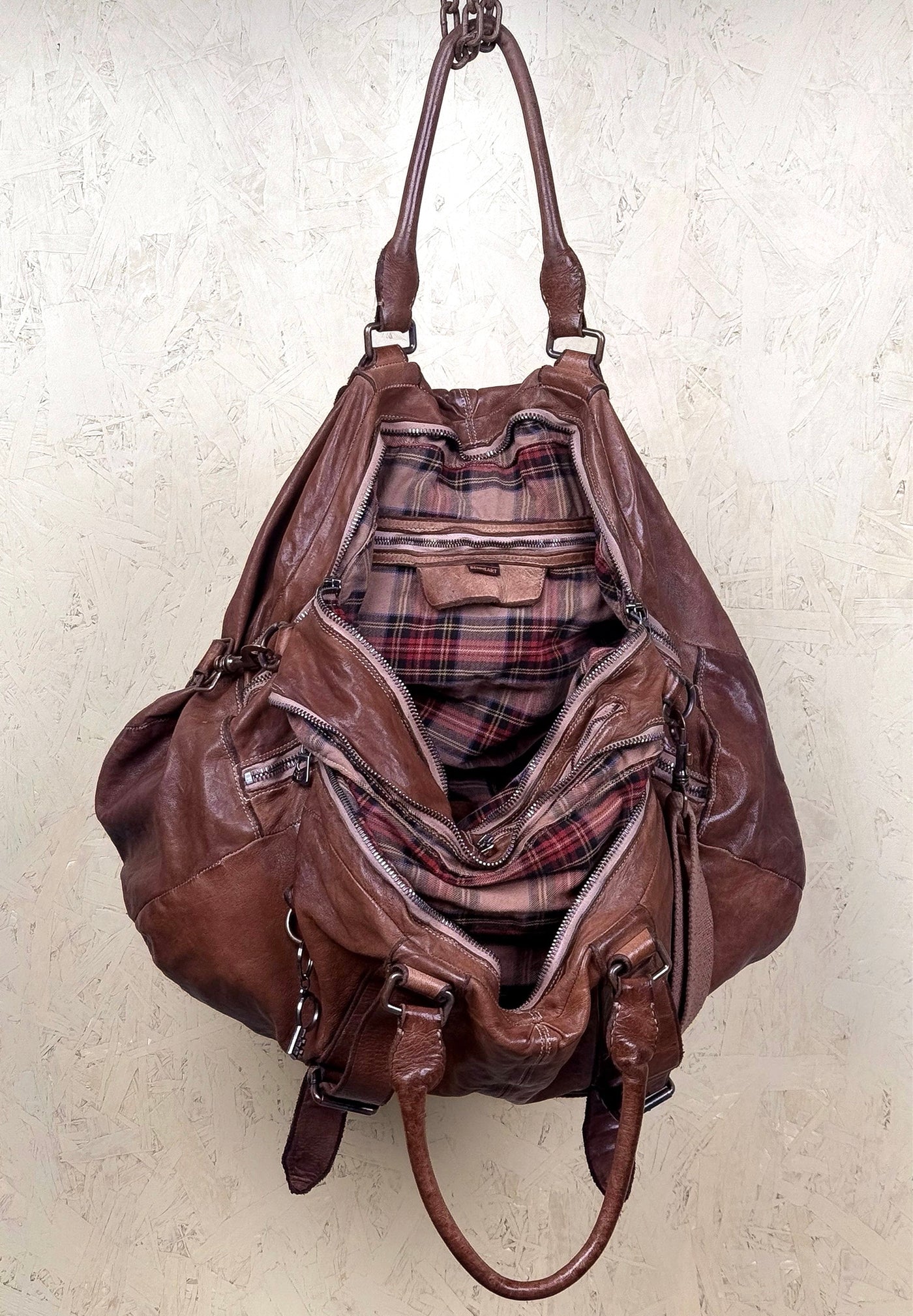 Open view of the Benheart Viaggio unisex cuoio leather travel bag, showing plaid fabric lining and internal compartments.