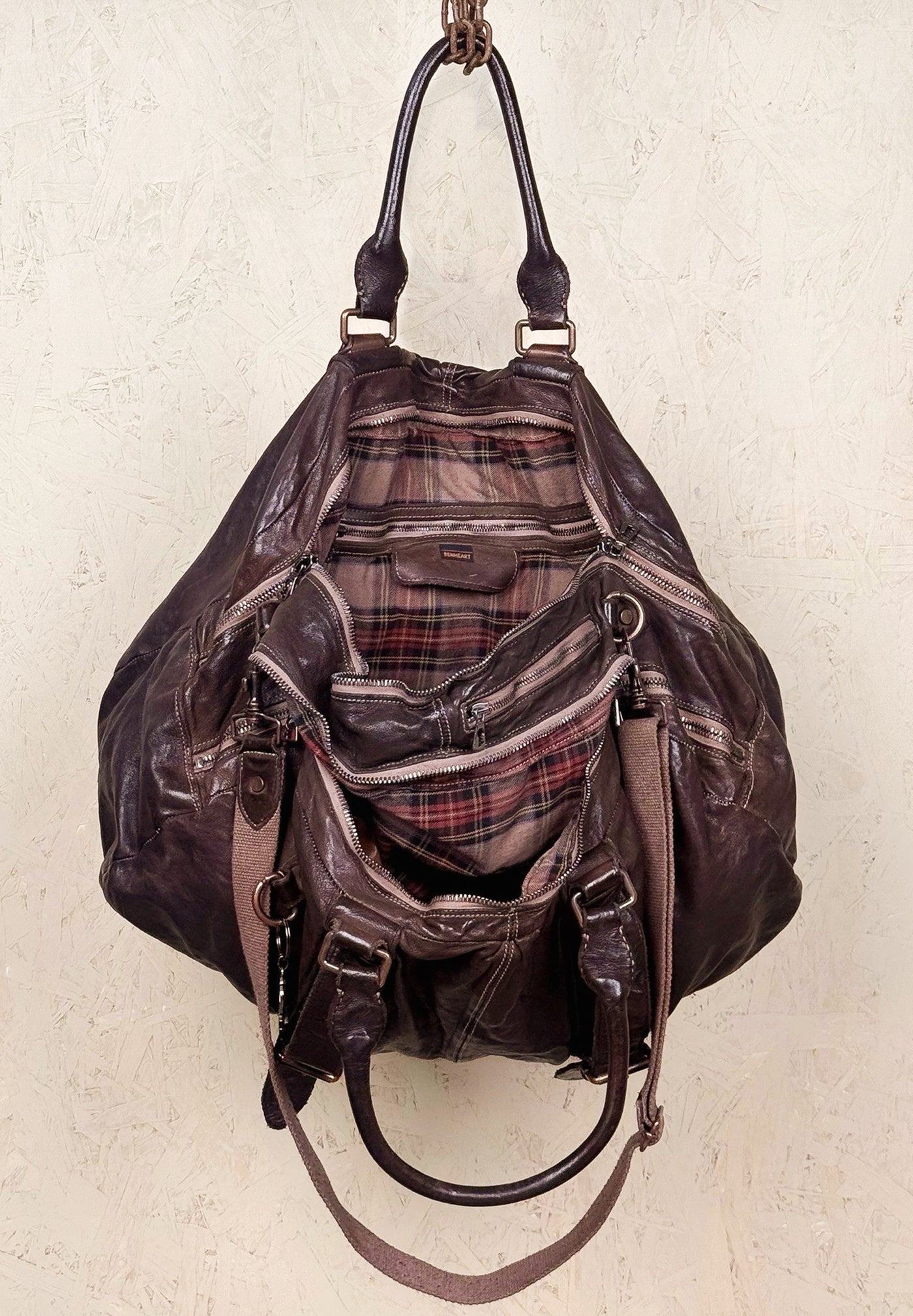 Open view of the Benheart Viaggio unisex brown leather travel bag, showing plaid fabric lining and internal compartments.