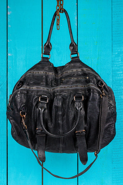 Angled front and top view of the Benheart Viaggio unisex black leather travel bag, showing multiple zippers, handles