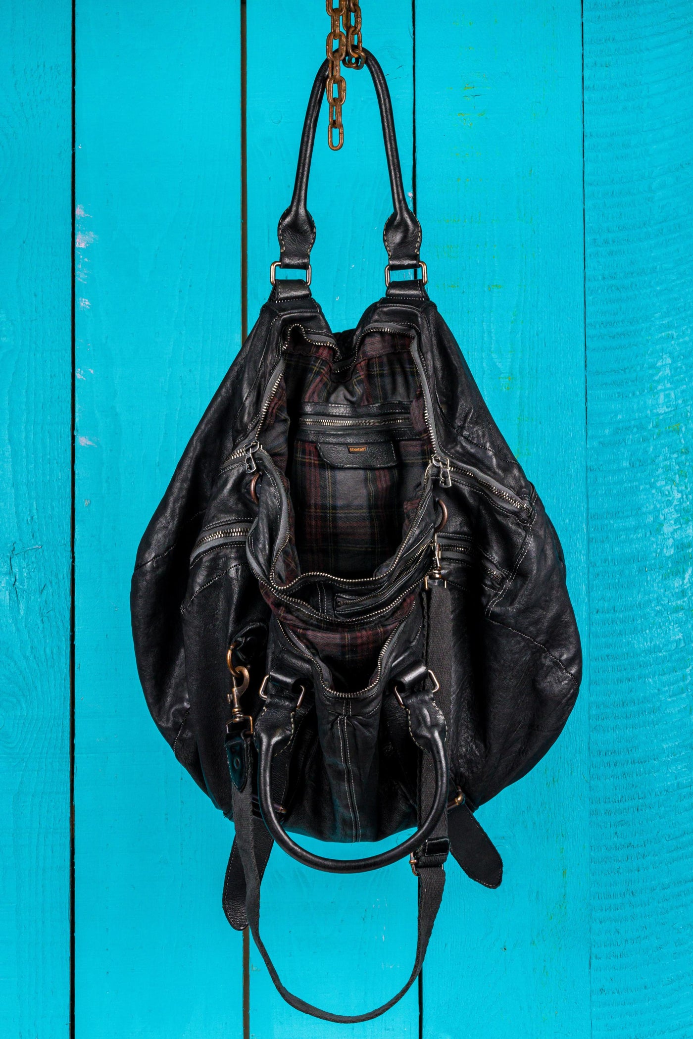 Open view of the Benheart Viaggio unisex black leather travel bag, showing plaid fabric lining and internal compartments.