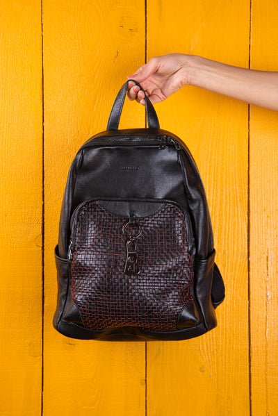 Model holding the Benheart Zoe women’s backpack with black and red weave, front view