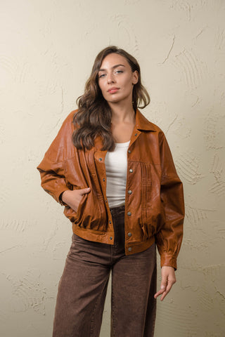 Jasmine women’s cognac lambskin leather jacket worn open over a white top, front view with classic collar and pleated chest.