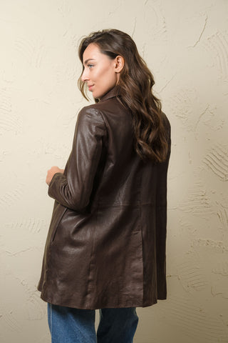 Woman wearing the Mini dark brown Italian leather A-line coat, three-quarter view