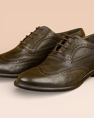 Details of a pair od DA VINCI leather shoes with wingtip (swallowtail-style), green forest green color (BOSCO).