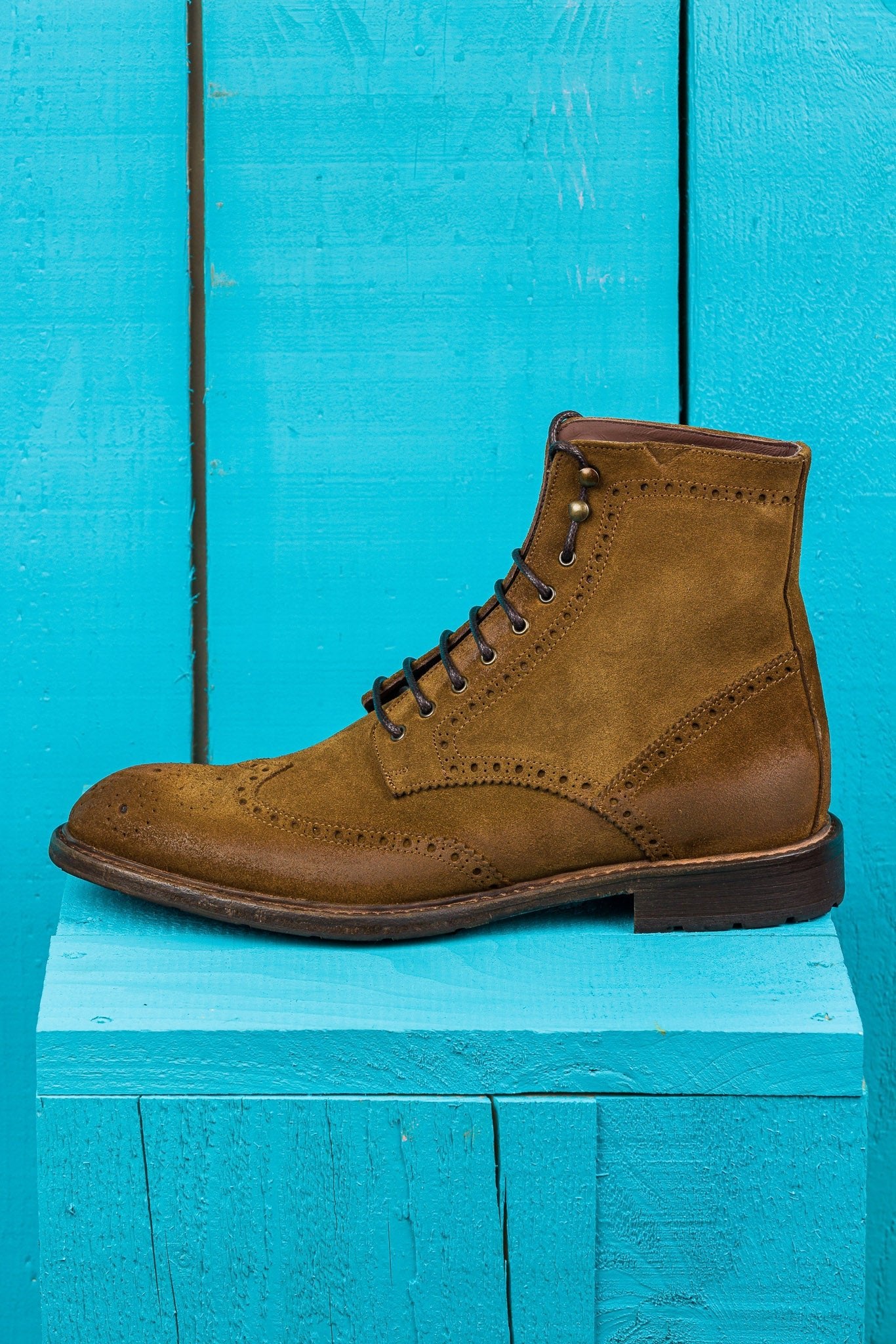 Side view of Benheart Daniel men’s lace-up brogue ankle boots with wingtip design in cognac suede.