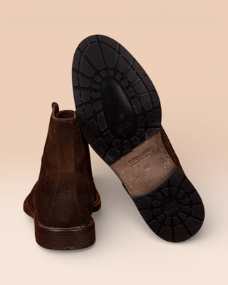 Detail of the Vibram sole of a pair of Benheart Daniel men’s brown cigar suede lace-up brogue ankle boots with wingtip design