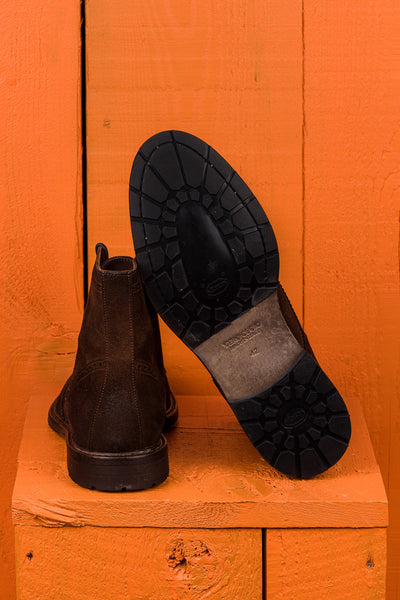 Detail of the Vibram sole of a pair of Benheart Daniel men’s brown cigar suede lace-up brogue ankle boots with wingtip design