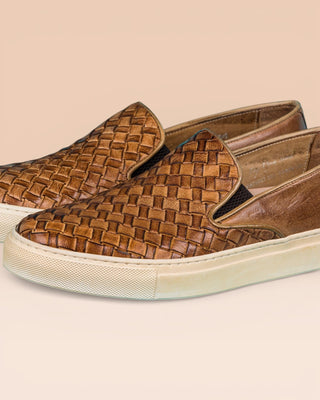 Close up view of Iris unisex woven slip-on shoes in cerro leather with white rubber soles.
