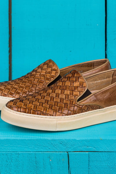 Close up view of Iris unisex woven slip-on shoes in cerro leather with white rubber soles.