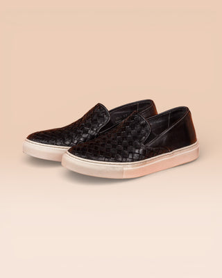 Front angled view of Iris unisex woven slip-on shoes in black leather with white rubber soles.