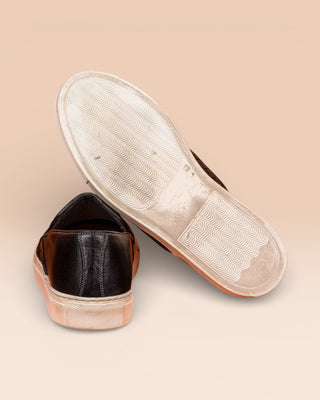 Rear view of Benheart Iris woven black leather slip-on shoes, one showing the heel and the other the rubber sole.