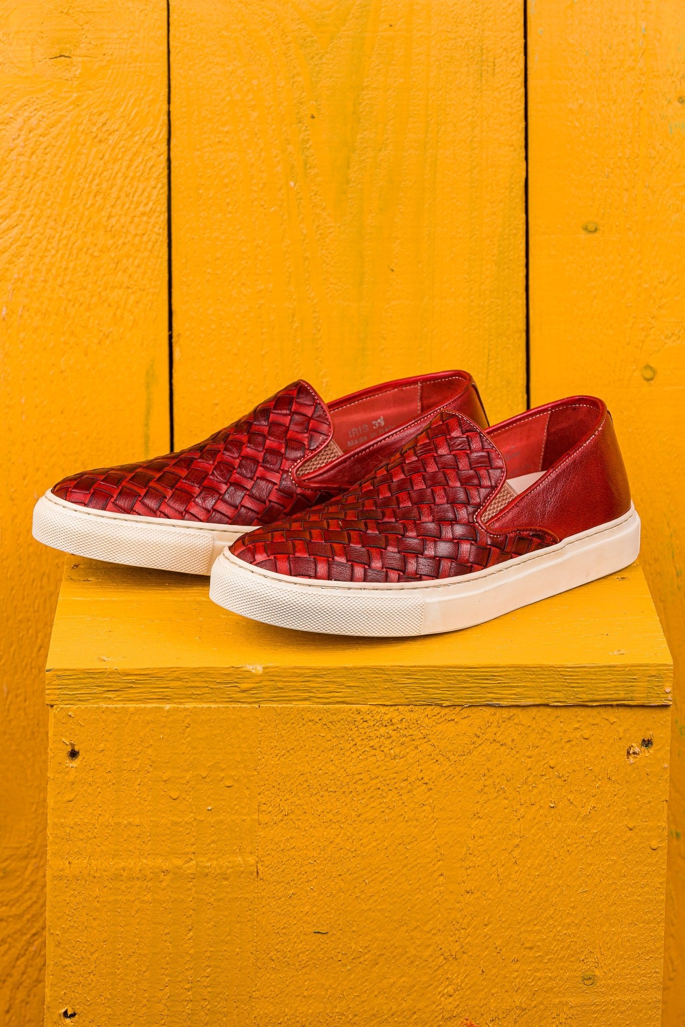 Front angled view of Iris unisex woven slip-on shoes in porpora leather with white rubber soles.