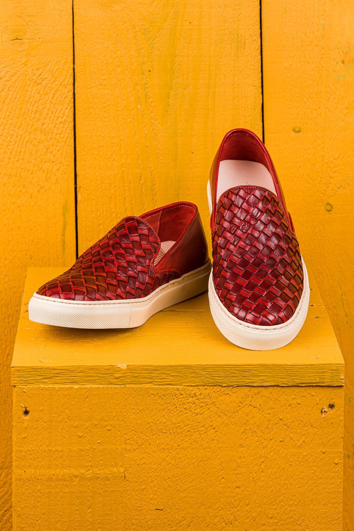front angled and top view of Iris unisex woven slip-on shoes in porpora leather with white rubber soles.