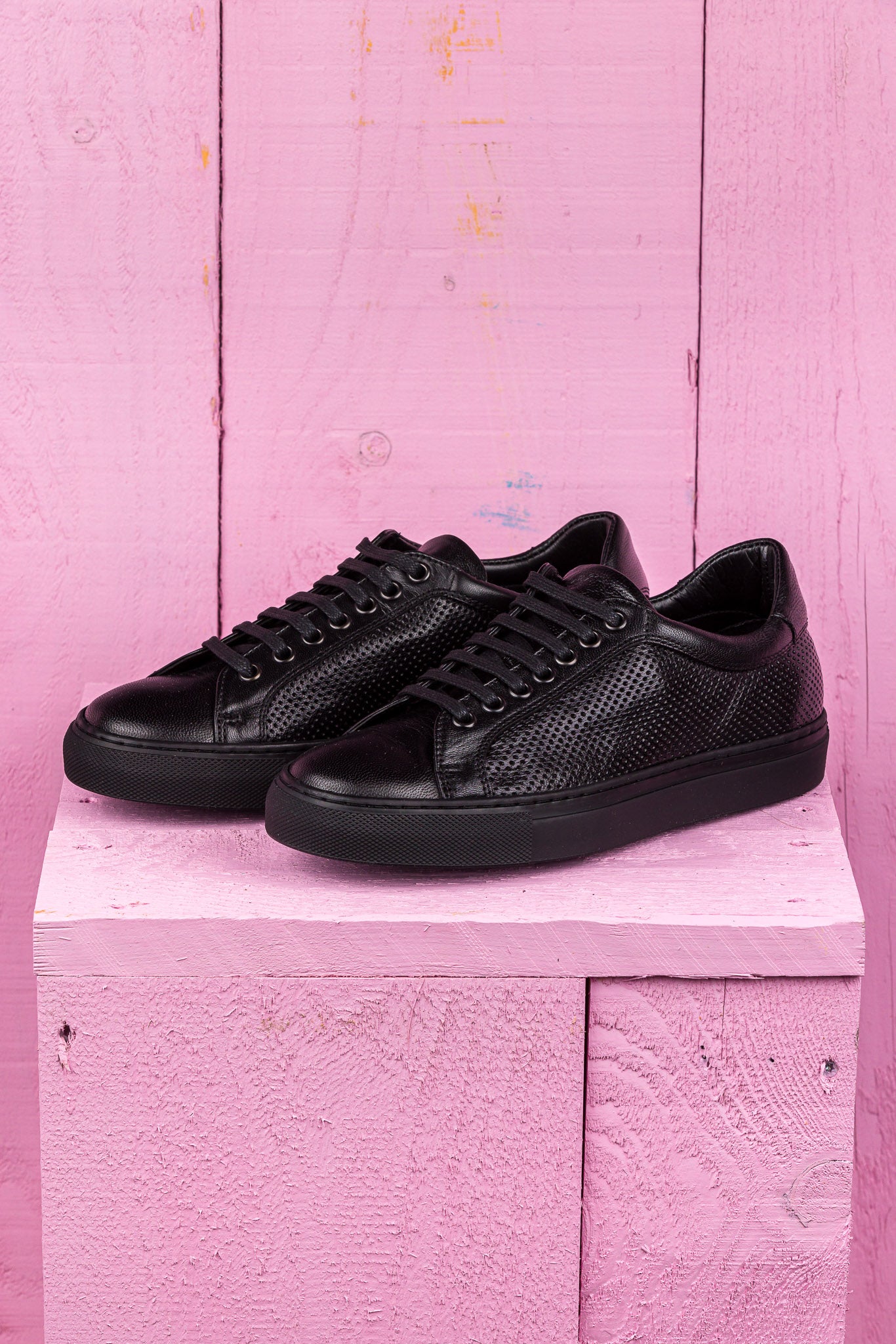 Benheart Lario unisex black perforated leather low-top sneakers, front angled view.
