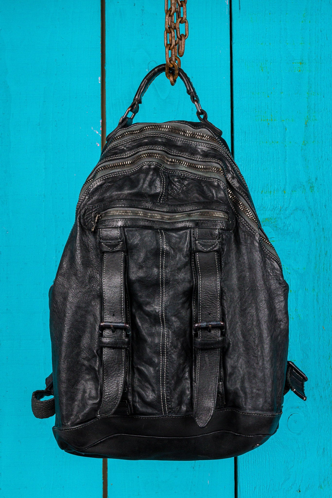 Front view of the Lorenzo unisex leather backpack in black, showing front pockets and zipper details.